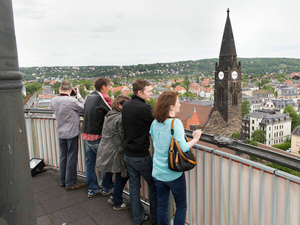 Besucherinnen und Besucher stehen auf der Aussichtsplattform des Ernemannturms und genießen den Blick über Dresden. 