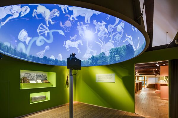 In einem digitalen Planetarium werden Sternbilder auf einen Schirm projiziert, der sich über den Besuchern befindet.
