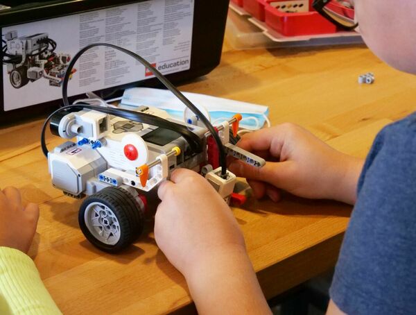 Ein Junge baut einen Lego-Mindstorm-Computer zusammen.